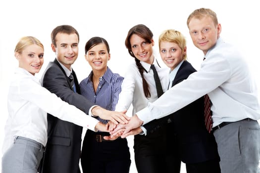 Portrait of friendly business team keeping their hands on top of each other and looking at camera