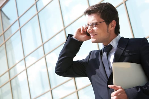 Photo of handsome employer speaking on mobile phone