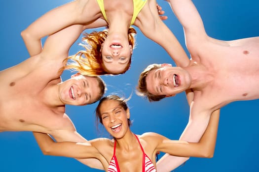 Down view of four friends touching each other's back by hands