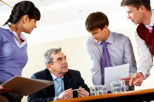 Image of boss listening to his co-workers in the boardroom