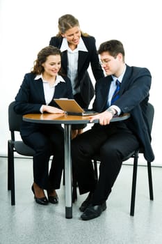 Portrait of successful business group interacting at working meeting and looking at laptop monitor