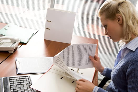 Pretty secretary working with papers in office
