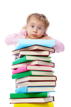 Portrait of a little girl holding on at a heap of books