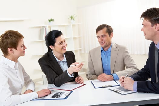 Portrait of businesswoman explaining work to his colleagues in office