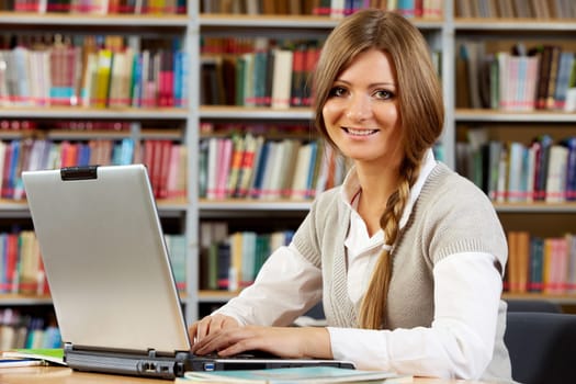 Portrait of clever student preparing lessons in college library