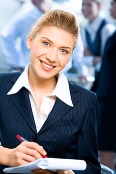 Portrait of strong secretary looking at camera during writing of text