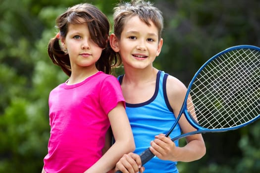 Portrait of a little girl and boy with badminton racket