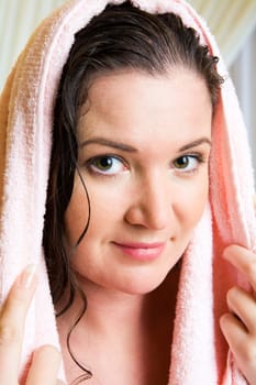 Close-up of charming woman with towel on head looking at camera