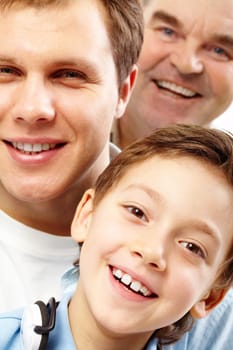 Close-up of a boys face looking at camera among his father and grandfather