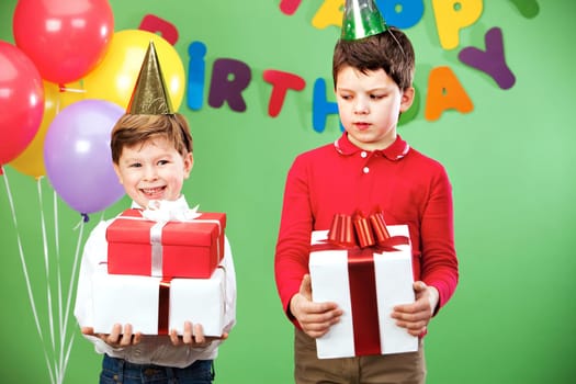 Portrait of two siblings on birthday party with giftboxes