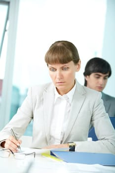 Portrait of serious woman working with papers in office