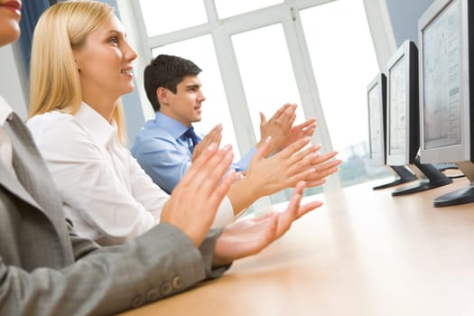Row of happy business partners applauding at conference
