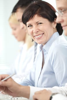 Mature businesswoman looking at camera between her partners