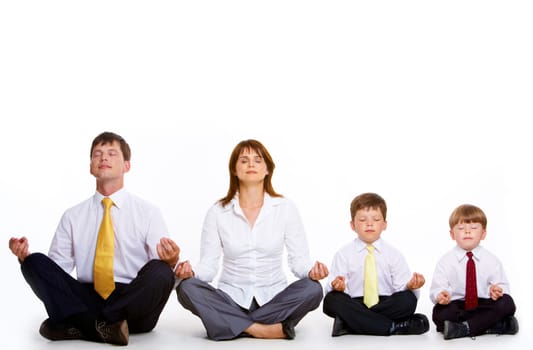 Photo of friendly family sitting in pose of lotus in a row and meditating over white background