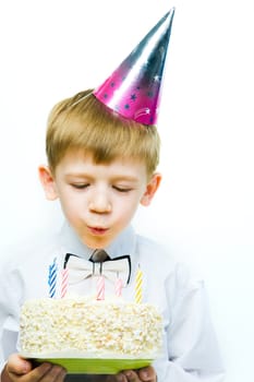 Image of boy blowing on the candles placed in the cake