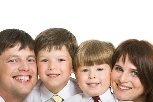 Faces of four family members looking at camera with happy smiles