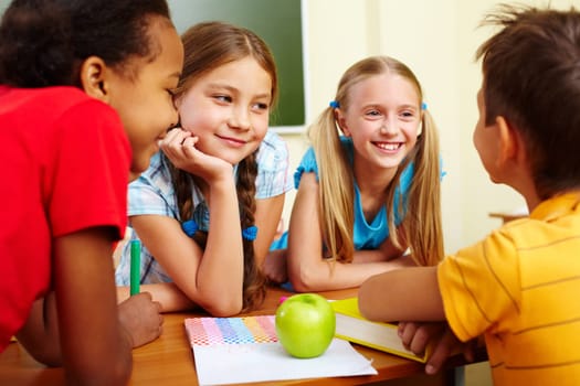 Portrait of joyful schoolchildren chatting in classroom
