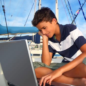 boy teenager seat on boat marina laptop computer summer vacation