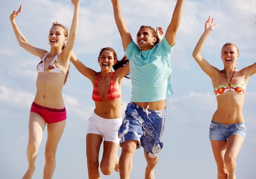Photo of happy friends running on background of cloudy sky
