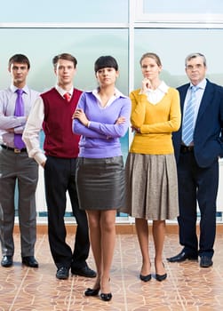 Photo of confident managers standing in office with young lady in front