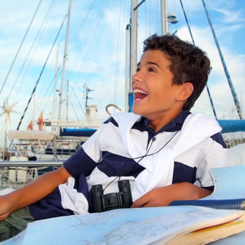 boy teen sailor laying on marina boat chart map smiling in summer vacation