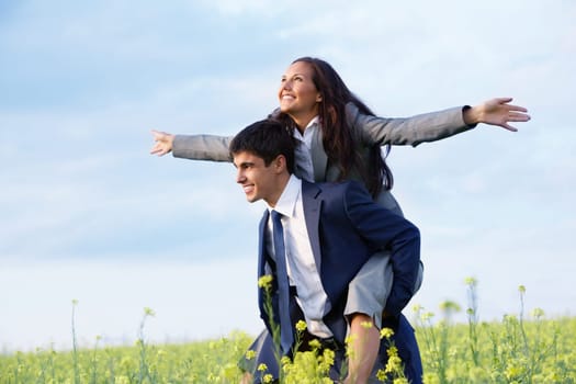 Portrait of happy business partners enjoying life and freedom in meadow