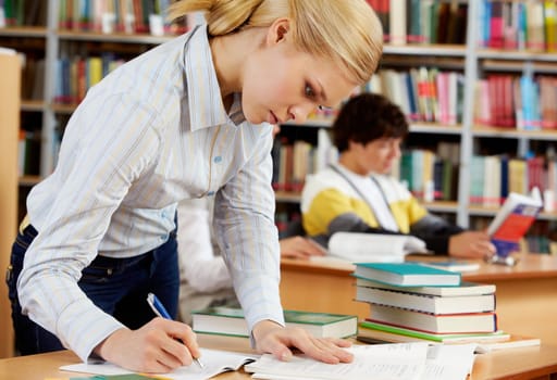 Portrait of serious blonde preparing lessons in college library
