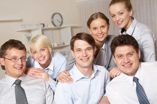 Portrait of friendly business people standing next to each other and looking at camera