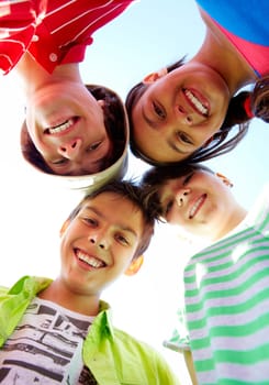Below view of several happy friends standing head by head to each other