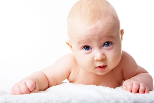 Photo of adorable infant crawling over fluffy rug