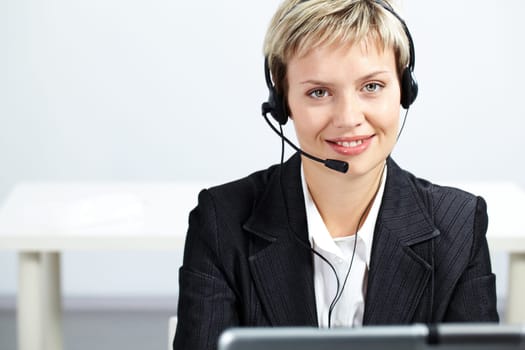 Portrait of pretty blond operator looking at camera and smiling