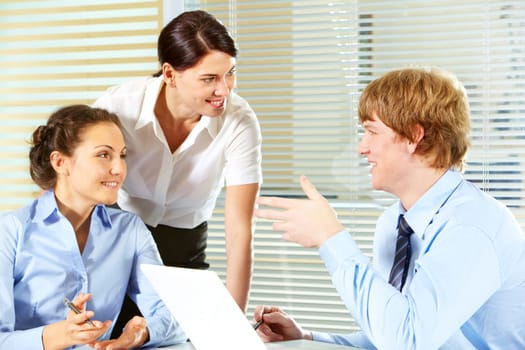 Portrait of friendly workteam discussing project in the office