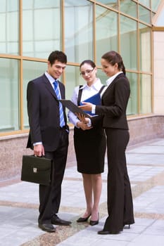 Portrait of busy people discussing new project or working plan outdoors