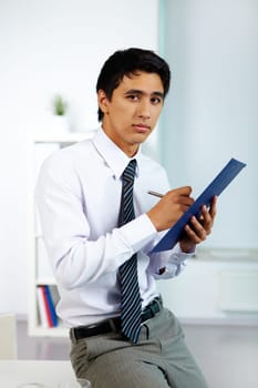 Portrait of a businessman writing plan of work in office