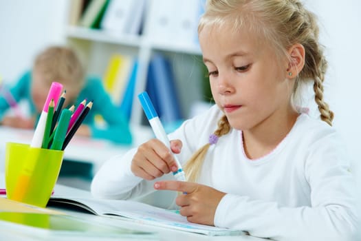 Portrait of lovely girl drawing with highlighters