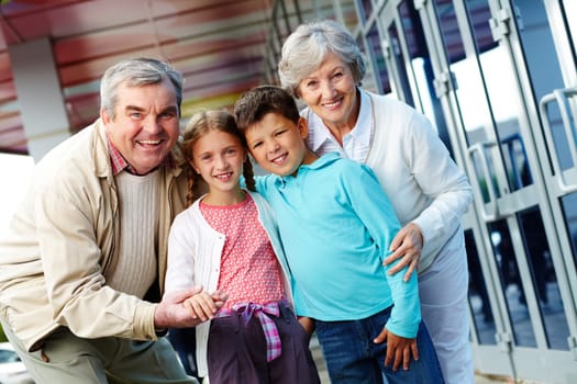 Portrait of happy grandparents and grandchildren by the mall