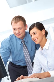 Leader and his secretary looking together at computer monitor