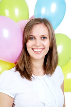 Pretty young woman looking at camera with colorful balloons on background