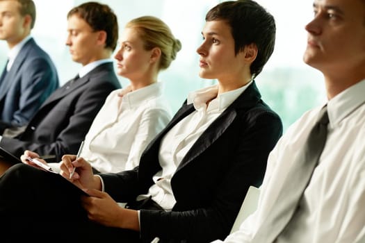Business people sitting in a row at seminar