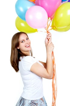 Pretty young woman looking at camera while holding colorful balloons