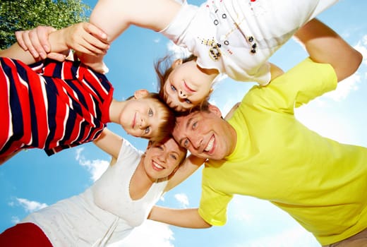 Family team of smiling people with cloudy sky above