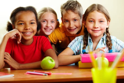 Portrait of smart schoolchildren looking at camera in classroom