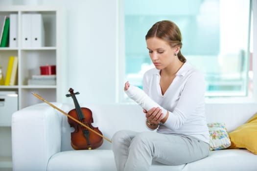 Portrait of a young violinist touching her broken arm