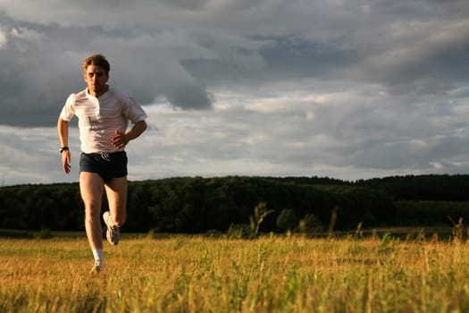 View of energetic man running in the forest