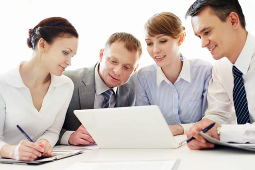 Four business people working with laptop in office