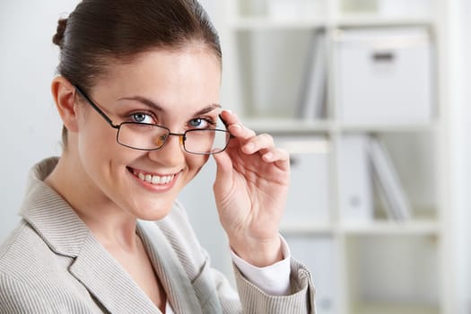 Portrait of successful businesswoman looking at camera through eyeglasses