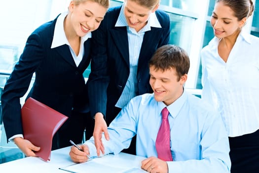Portrait of confident boss sitting at the table in an environment of business women