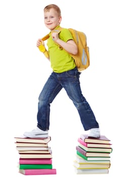 A boy with satchel walking on two heaps of books