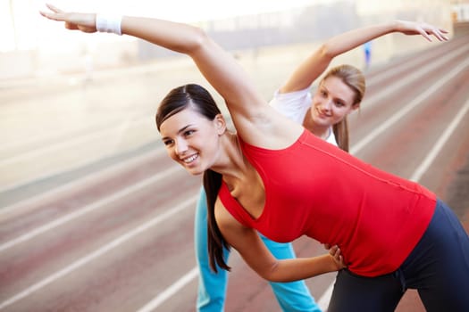 A young girl making exercises together with her girlfriend