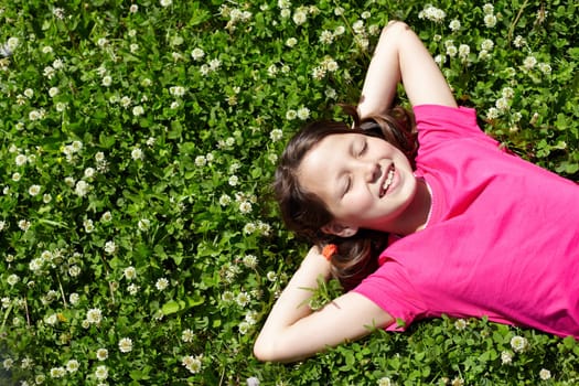 High angle view of a little girl resting on grass